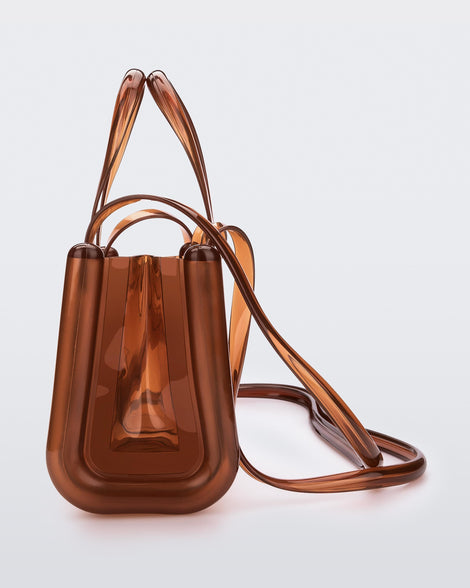 Side view of a brown small Melissa Jelly Shopper bag + Telfar bag with a handle and straps.