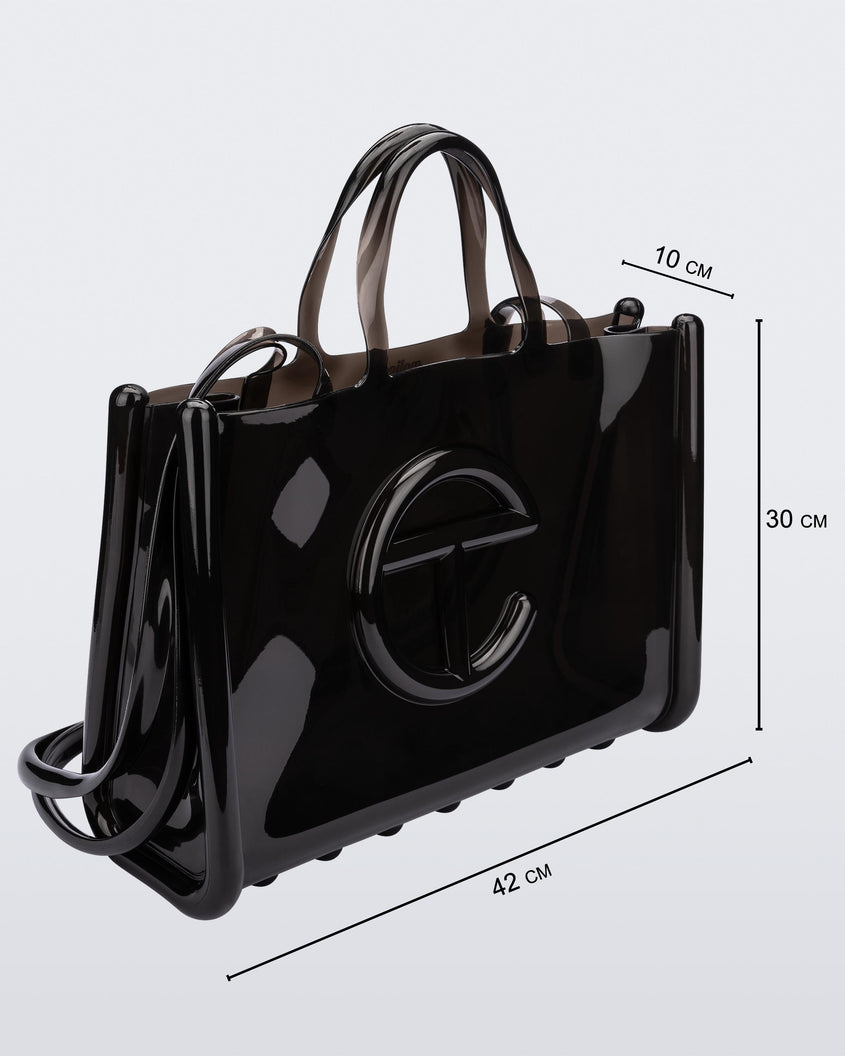Angled view of a black large Melissa Jelly Shopper bag + Telfar bag with a handle and straps. Dimensions 42 cm length, 10 cm width, 30 cm height