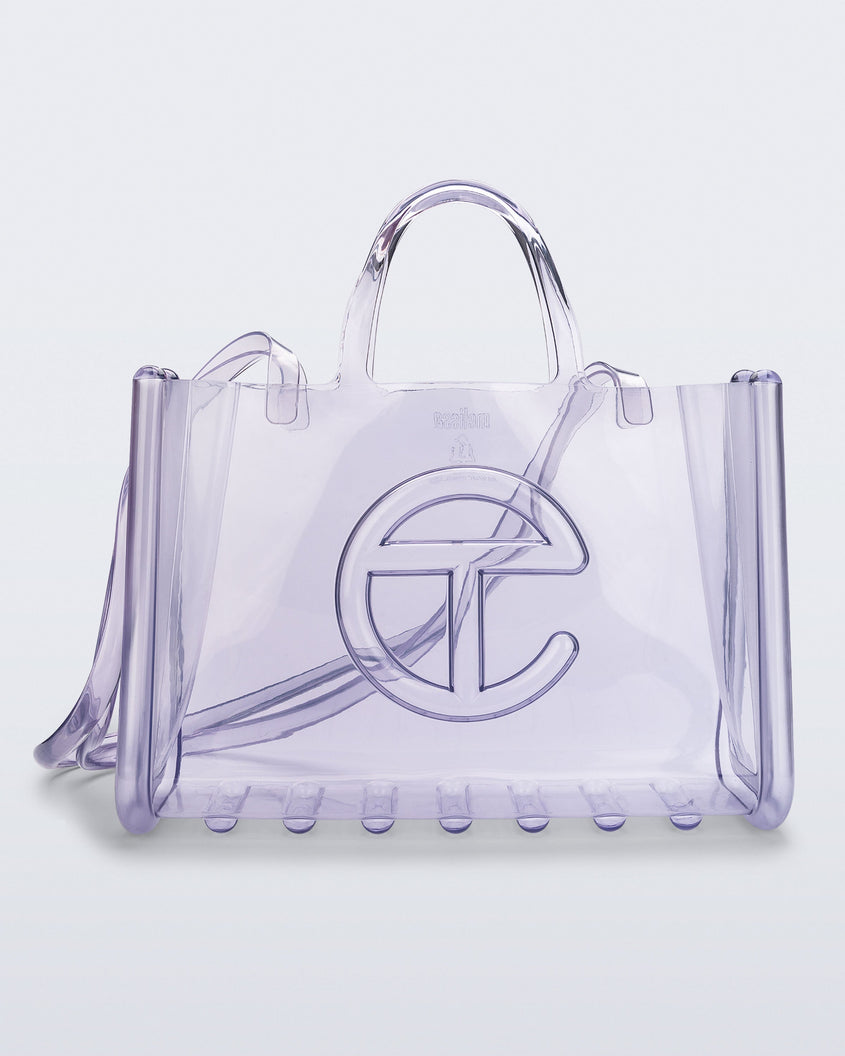 Front view of a clear Melissa Large Jelly Shopper + Telfar bag with handles and a body strap
