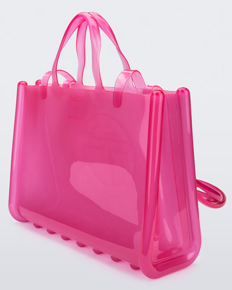 Angled view of a pink large Melissa Jelly Shopper bag + Telfar bag with a handle and straps.