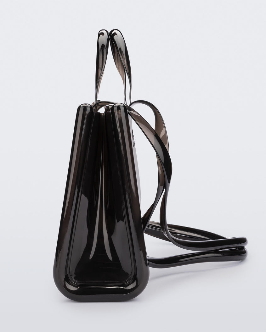 Side view of a black medium Melissa Jelly Shopper bag + Telfar bag with a handle and straps.