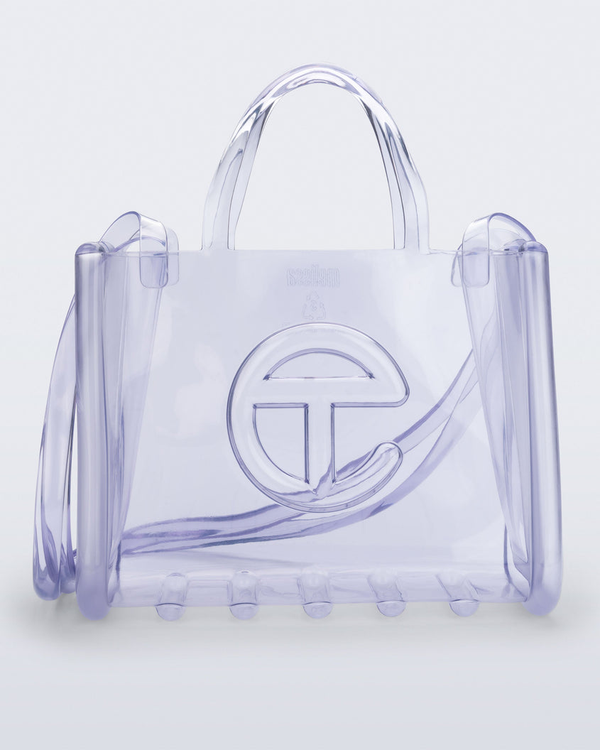 Front view of a clear Melissa Medium Jelly Shopper + Telfar bag with handles and a body strap