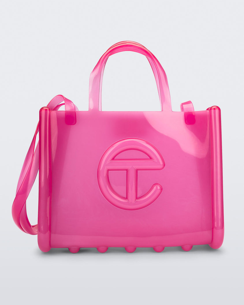 Front view of a pink medium Melissa Jelly Shopper bag + Telfar bag with a handle and straps.