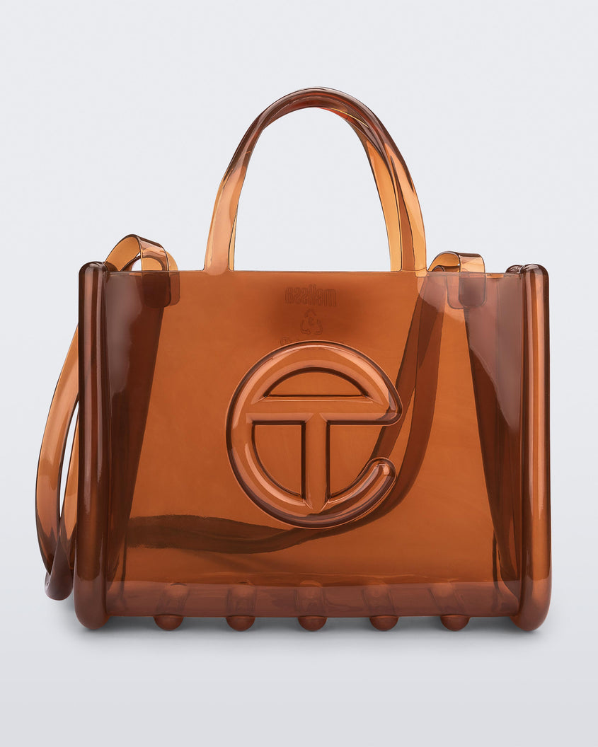 Front view of a brown medium Melissa Jelly Shopper bag + Telfar bag with a handle and straps.