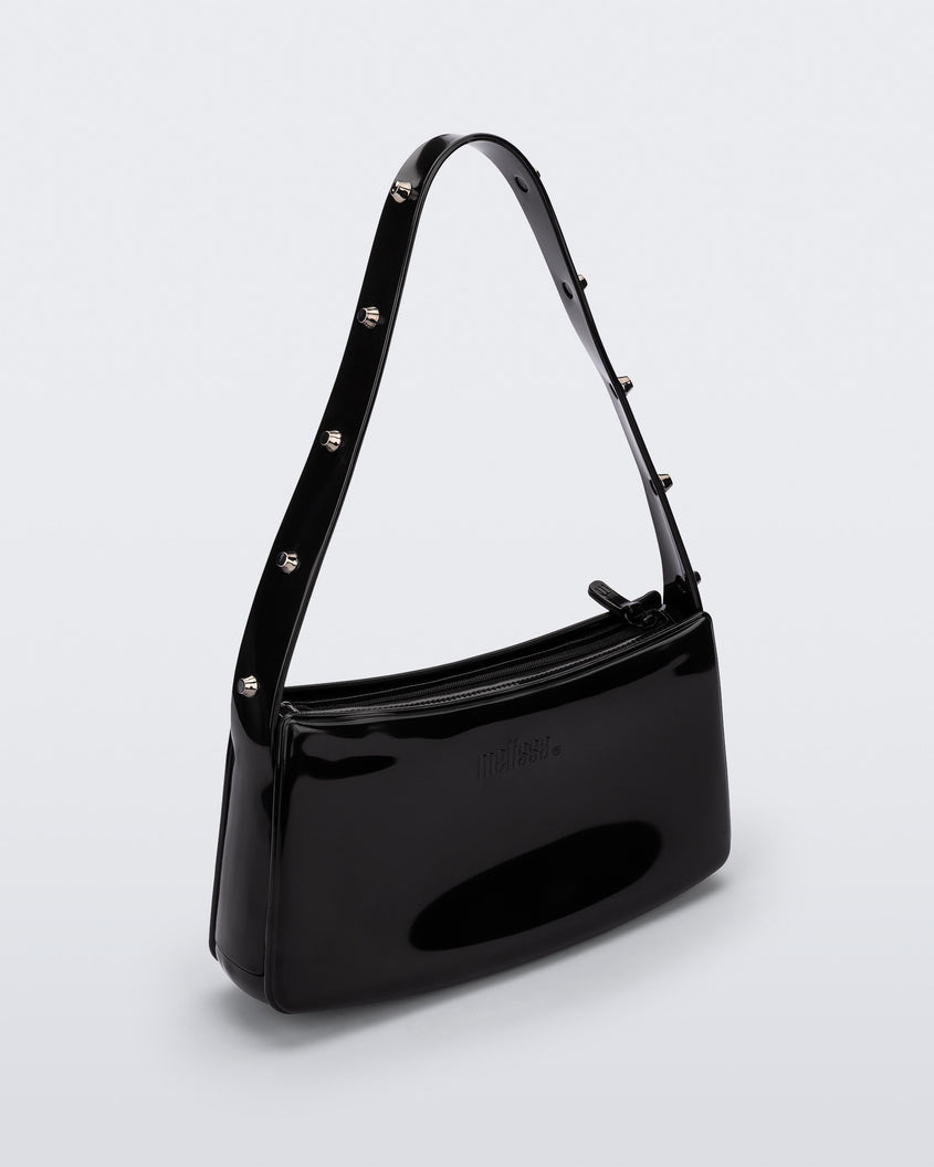 Angled view of the black Melissa Baguete Studs bag with a short studded strap.