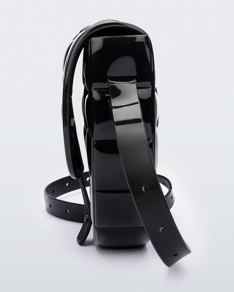 Side view of a black Possession Bag with strap.