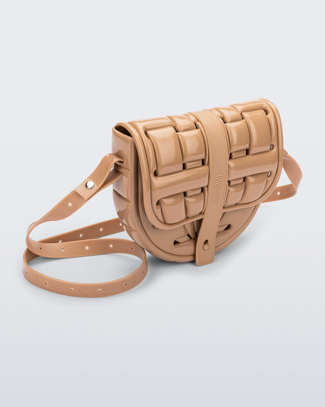 Angled front view of a beige Possession Bag with strap.
