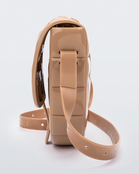 Side view of a beige Possession Bag with strap.