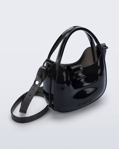 Angled view of a clear black Mirror bag with cross body straps two clear handles.