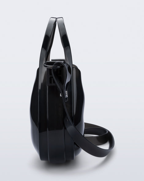 Side view of a clear black Mirror bag with cross body straps two clear handles.