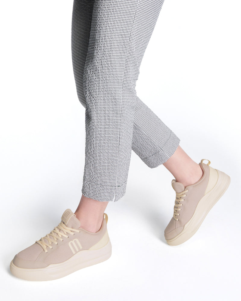 Model's legs wearing a pair of beige X Mood sneakers