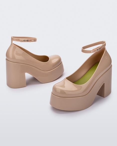 Angled view of a pair of beige Melissa Doll Heel platforms with ankle strap and green insole.