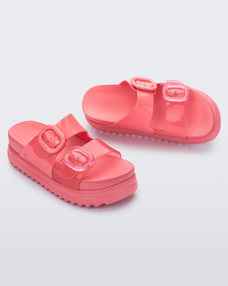 Angled view of a pair of pink Cozy Platform slides.