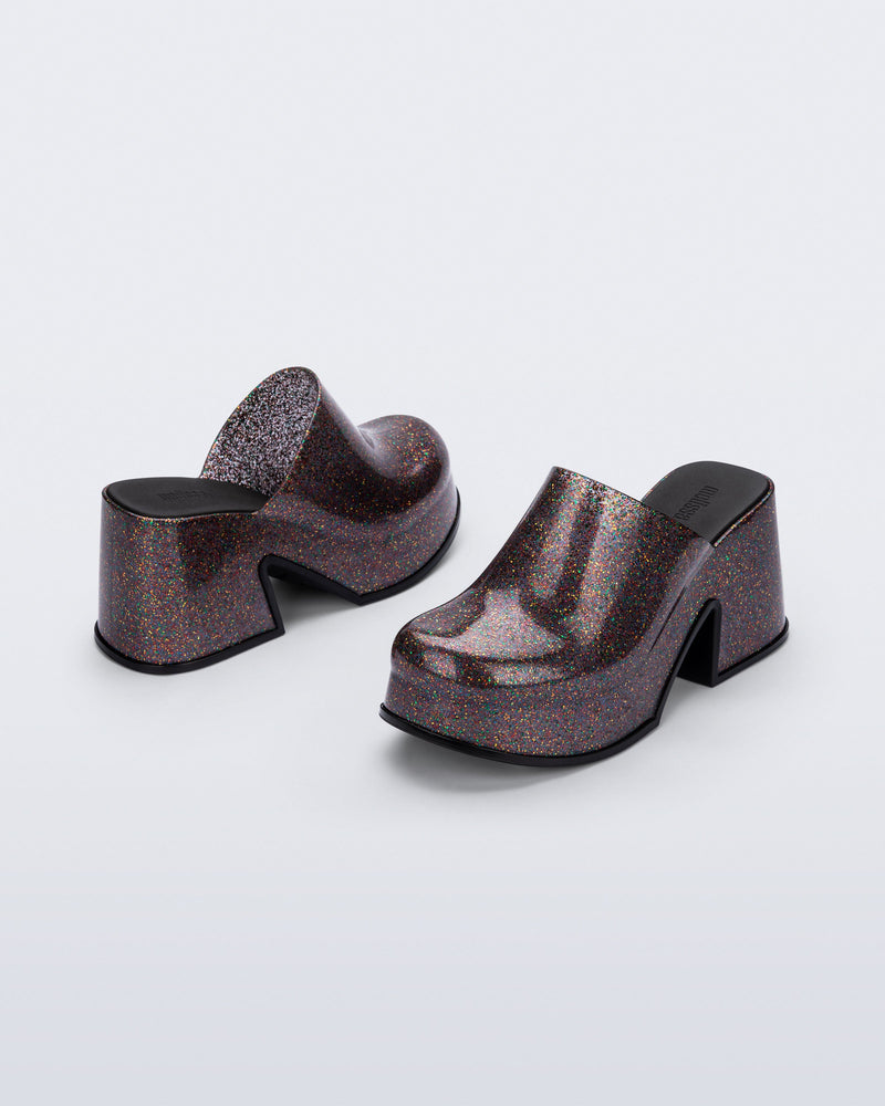 Side and back angled view of a pair of mixed glitter Mia mules with black sole