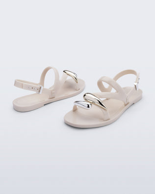 Back and angled view of a pair of beige Iris sandals with gold upper embellishments