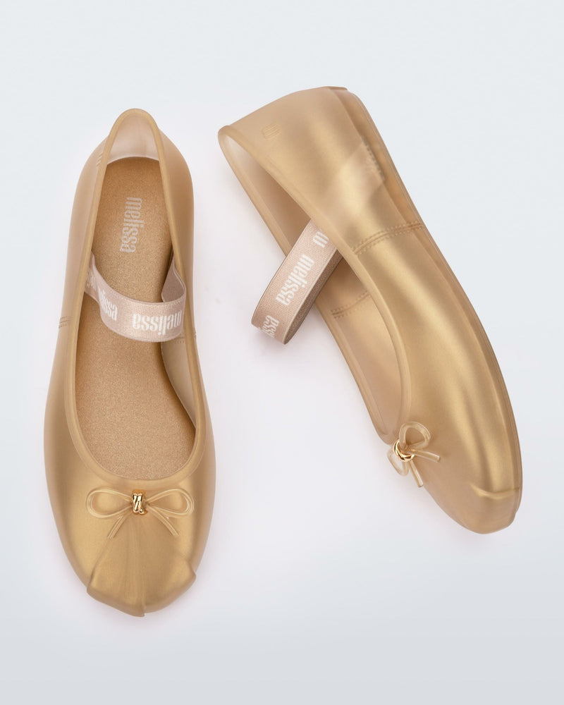 Side and top view of a pair of gold Sophie flats.