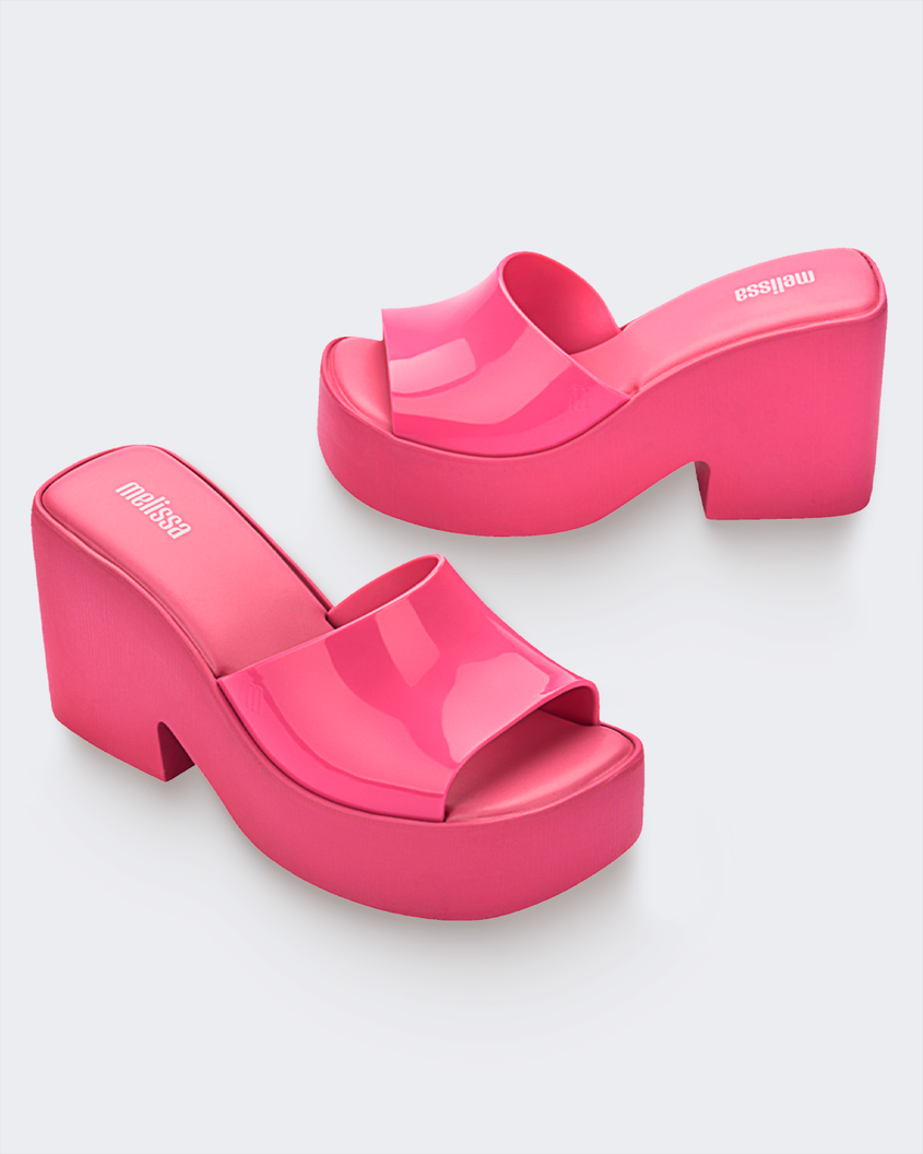 A side and angled view of a pair of pink Melissa Posh platform slide heels