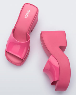 Top and side view of a pair of Melissa Posh platform slides in pink