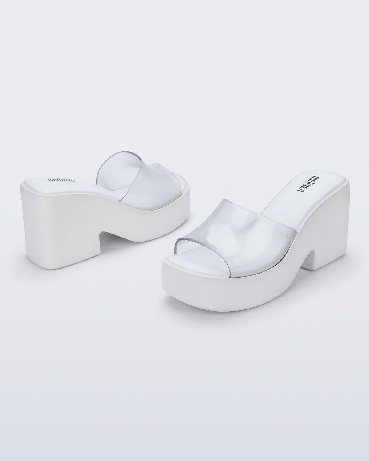 Back and angled view of a pair of white with clear upper Posh platform heel sandals