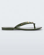 Side view of a green Melissa Harmonic Studs flip flop with gold studs on the upper.