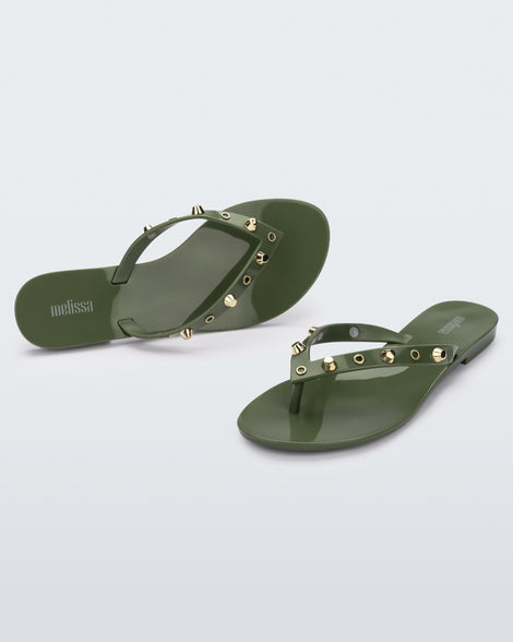 Angled and top view of a pair of green Melissa Harmonic Studs flip flops with gold studs on the upper.