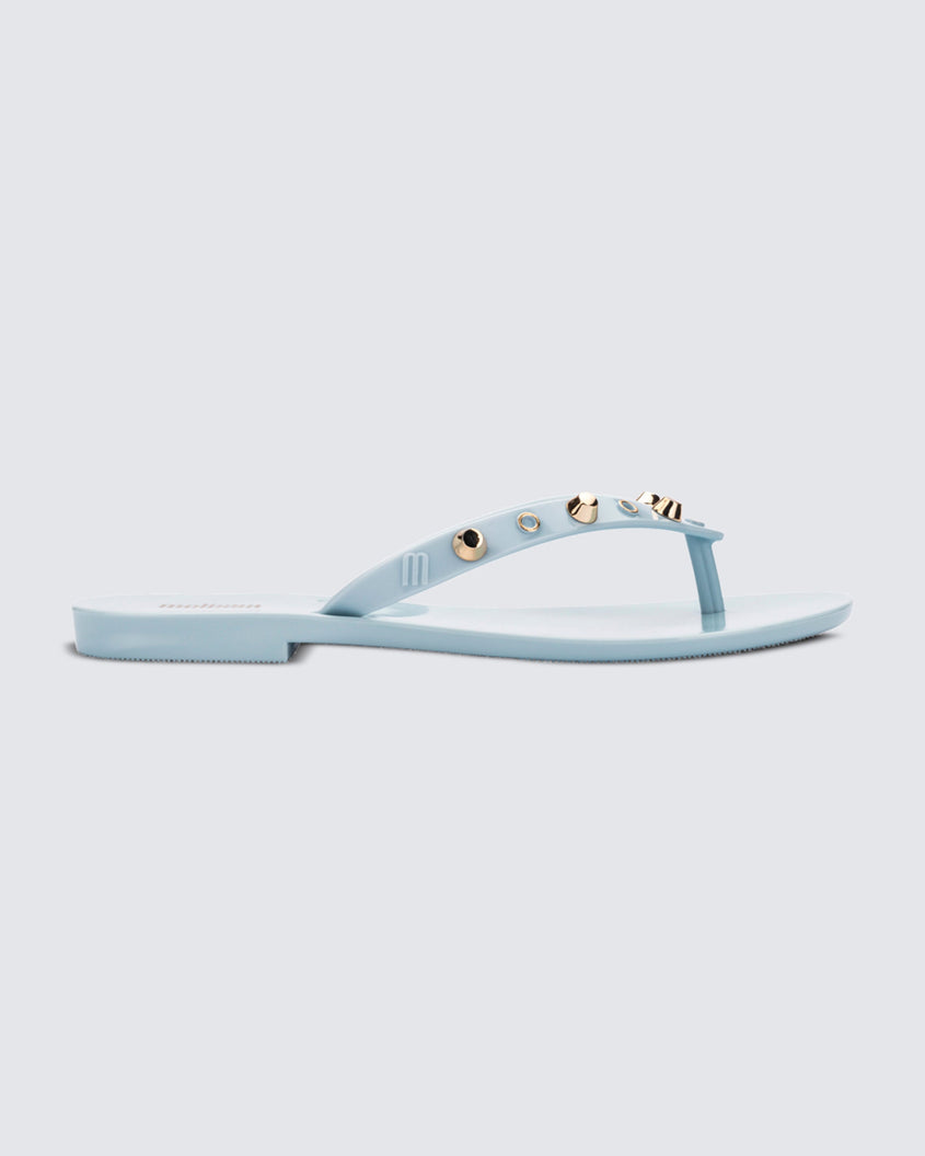 Side view of a blue Melissa Harmonic Studs flip flop with gold studs on the upper.