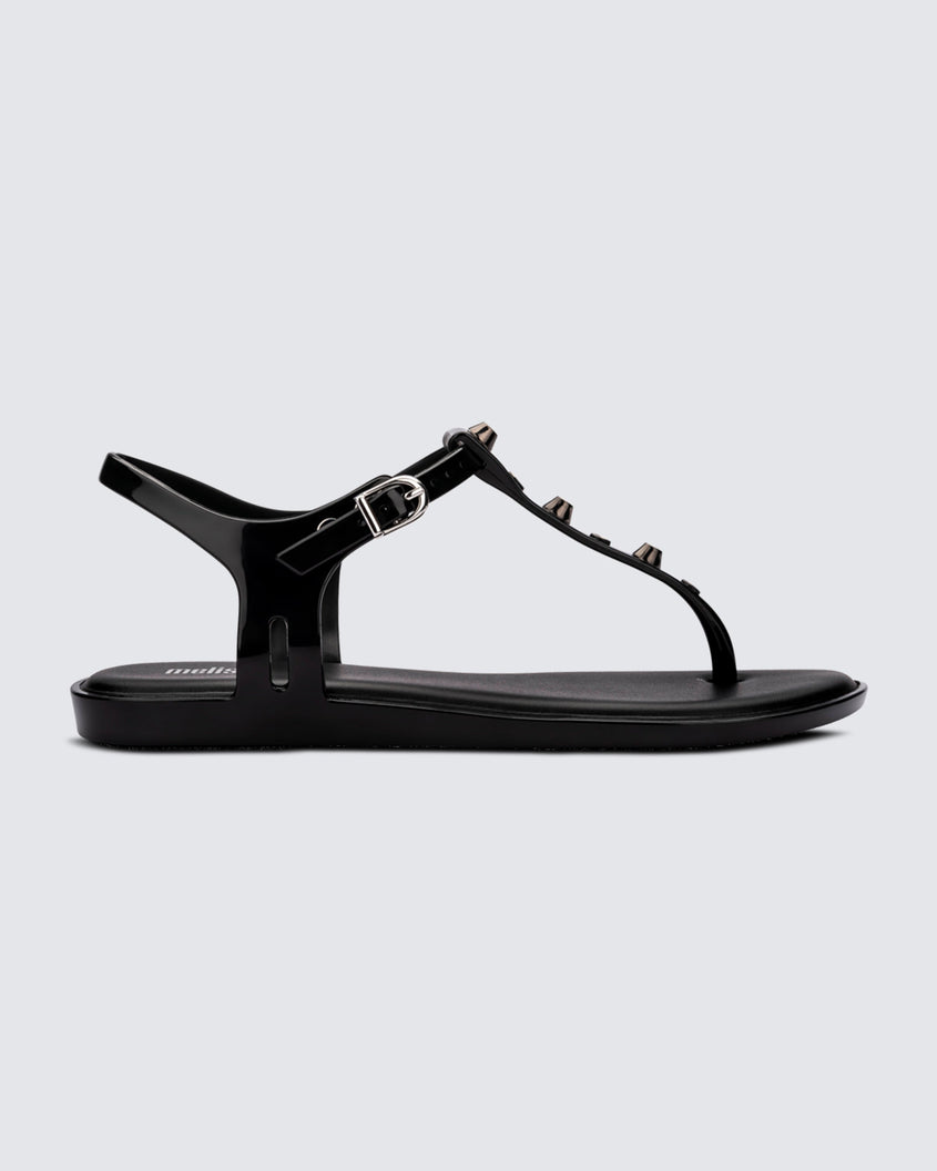 Side view of a black Melissa Solar studs sandal with gold studded t-strap and gold buckle.