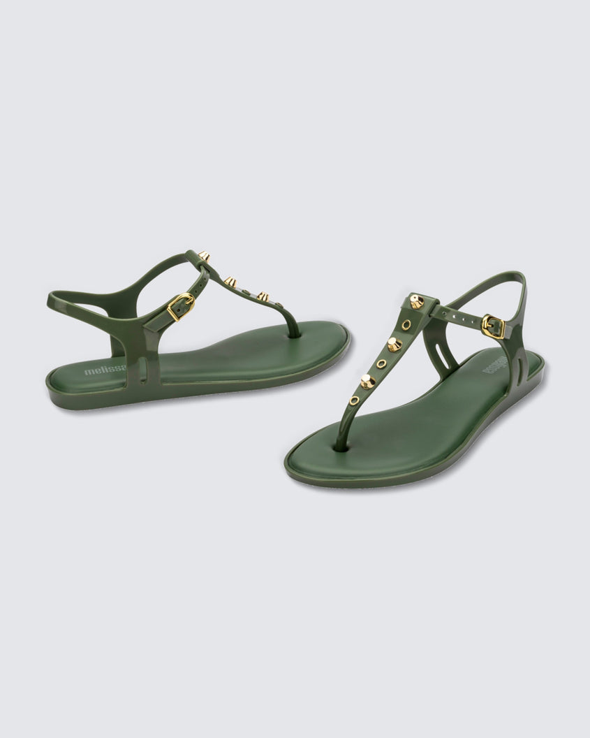 Angled and side view of a pair of green Melissa Solar studs sandals with gold studded t-strap and gold buckle.