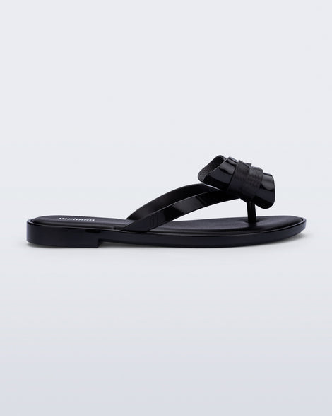 Side view of a black Slim Flop flop with bow