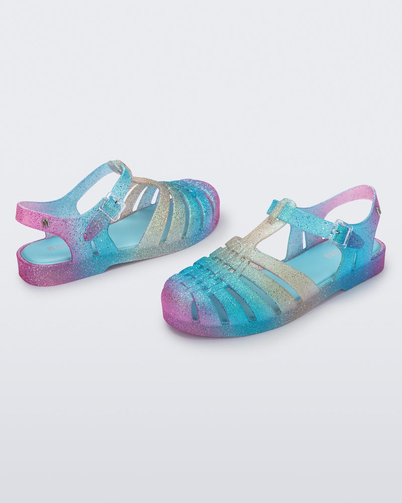 Angled view of a pair of blue and pink glitter Possession sandals.