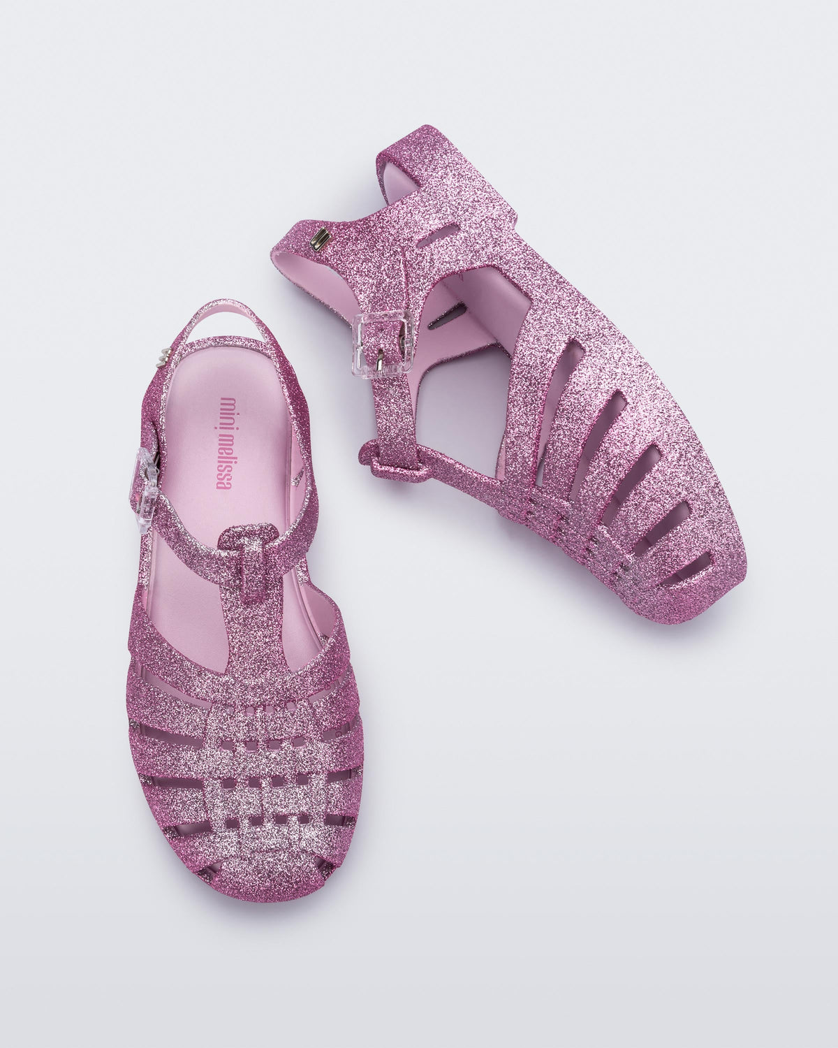 Top and side view of a pair of glitter pink kids Possession sandals.
