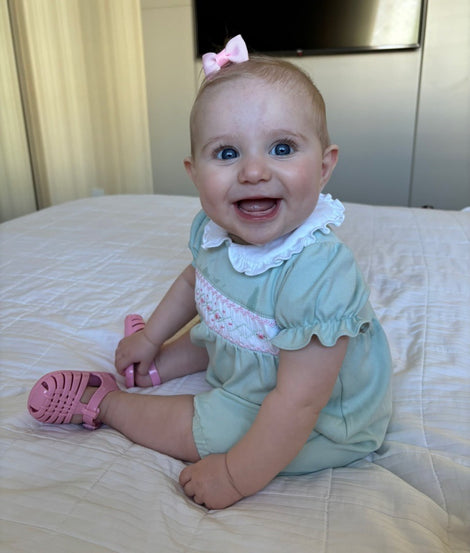 baby model wearing a pair of pink My First Possession fisherman sandals