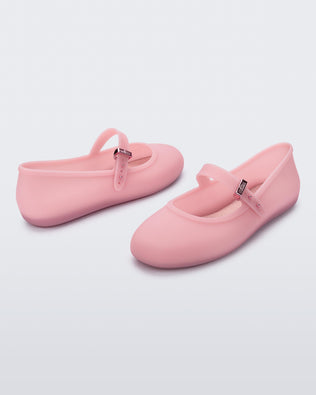 Back and front angled view of a pair of milky pink Soft Ballerina flats with a strap and buckle