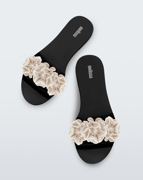 Top view of a pair of black Babe Springtime women's slide with 3 beige flowers.