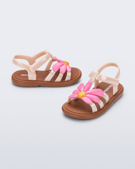 Side and angled view of a pair of pink Hip Bloom kids sandals with pink flower 