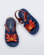 Top view of a pair of glitter blue Hip Bloomy baby sandals with red daisy on top and red straps