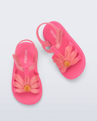 Top view of a pair of glitter pink Hip Bloomy baby sandals with pink daisy on top