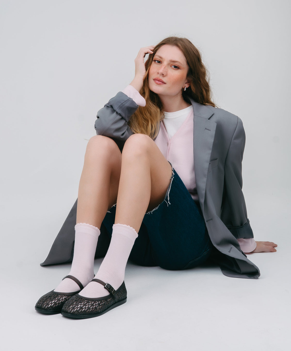 Model in a grey sports coat and jean shorts wearing a pair of black Harper Ballerina flats with ankle white socks