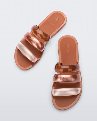 Top view of a pair of brown Eclipse Slides with gold and bronze straps.