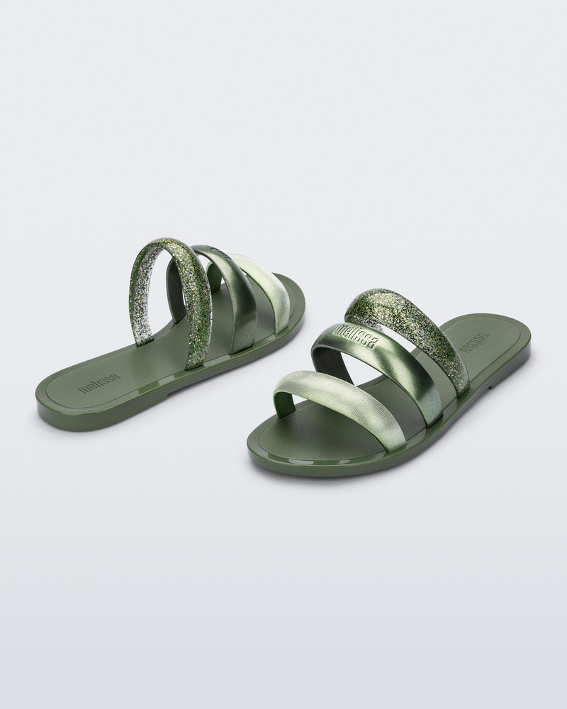 Back and angled view of a pair of green Eclipse Slides with glitter green straps.