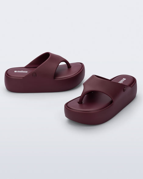 Side and angled view of a pair of burgundy Free Platform Thong sandals