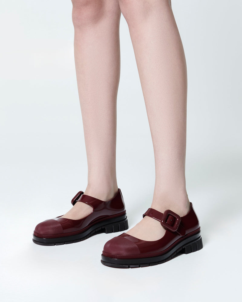 Model's legs wearing  a pair of burgundy June mary janes with matte toe cap
