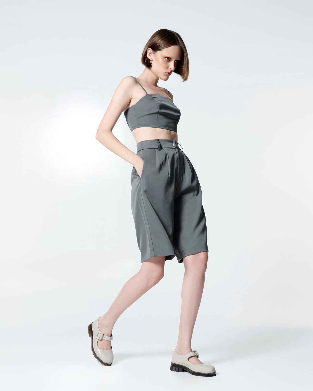 Model in a grey outfit wearing  a pair of beige with brown sole June mary janes with matte toe cap