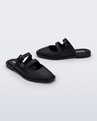 Side and angled view of a pair of matte black Anastasia slide mules