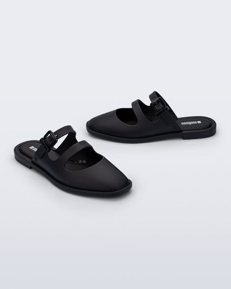 Side and angled view of a pair of matte black Anastasia slide mules