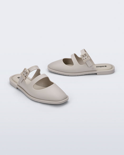 Angled and side view of a pair of matte beige Anastasia slide mules