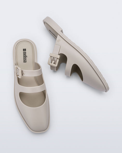 Top and side view of a pair of matte beige Anastasia slide mules
