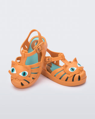 Angled view of a pair of orange baby Possession Cat sandals