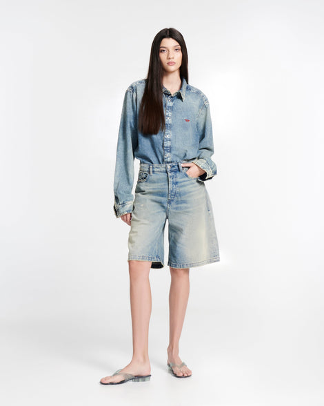 Model in jean shorts and jean button down shirt wearing a pair of transparent green Flip Flop + Diesel sandals