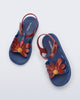 Top view of a pair of glitter blue Hip Bloomy kids sandals with red daisy on top and red straps